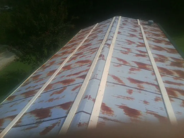 Rusted metal roof panels with new wood purlins before replacement — Storm Damage Roof Repair in Reinbeck by Roofing Brothers